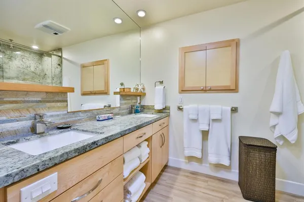 a bathroom with a granite countertop sink and a mirror
