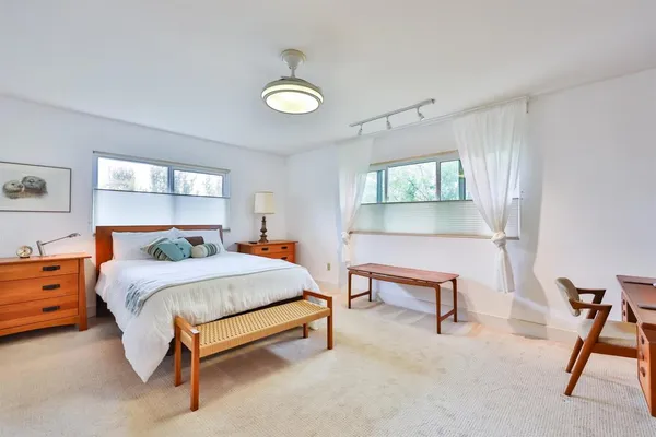 a bedroom with a bed chair and window