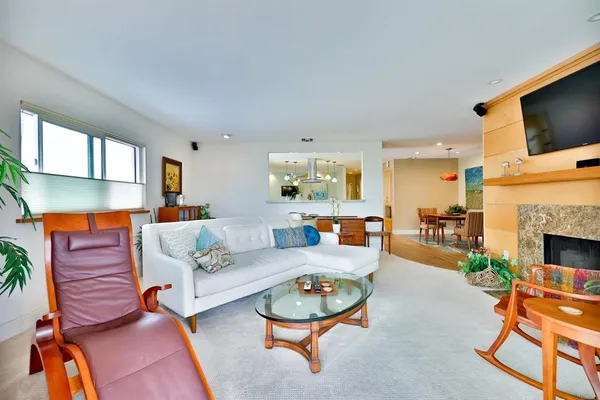 a living room with furniture a fireplace and flat screen tv