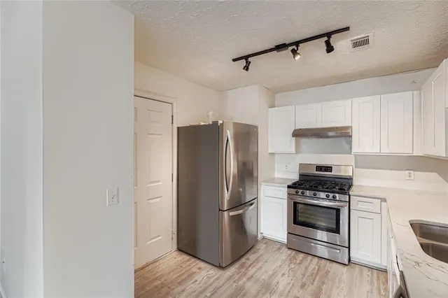 a kitchen with stainless steel appliances a refrigerator stove and microwave