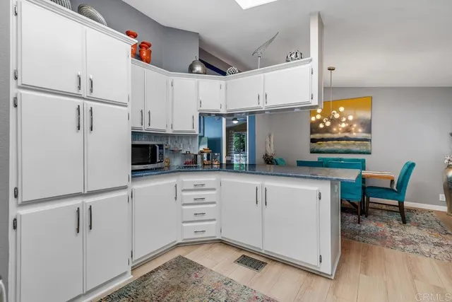 a kitchen with granite countertop white cabinets and white appliances