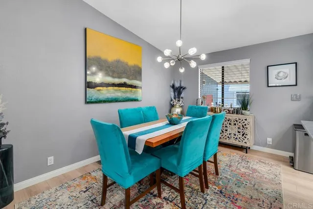 a view of a dining room with furniture a chandelier and wooden floor