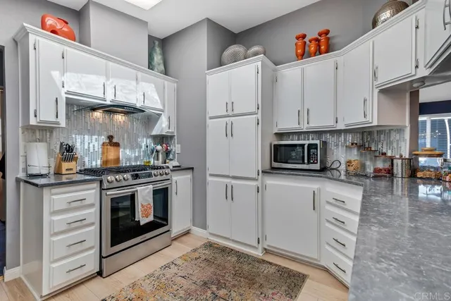 a kitchen with stainless steel appliances granite countertop a stove a refrigerator and a cabinets