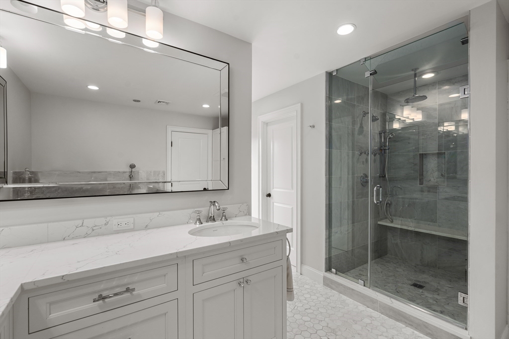 96 Oldham Road Newton, MA 02465 - Photo 15 of 40 a bathroom with a shower sink and mirror