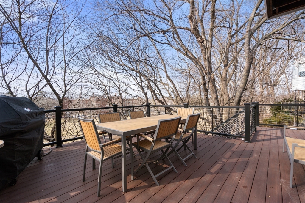 96 Oldham Road Newton, MA 02465 - Photo 30 of 40 a view of a roof deck with table and chairs with wooden floor and fence