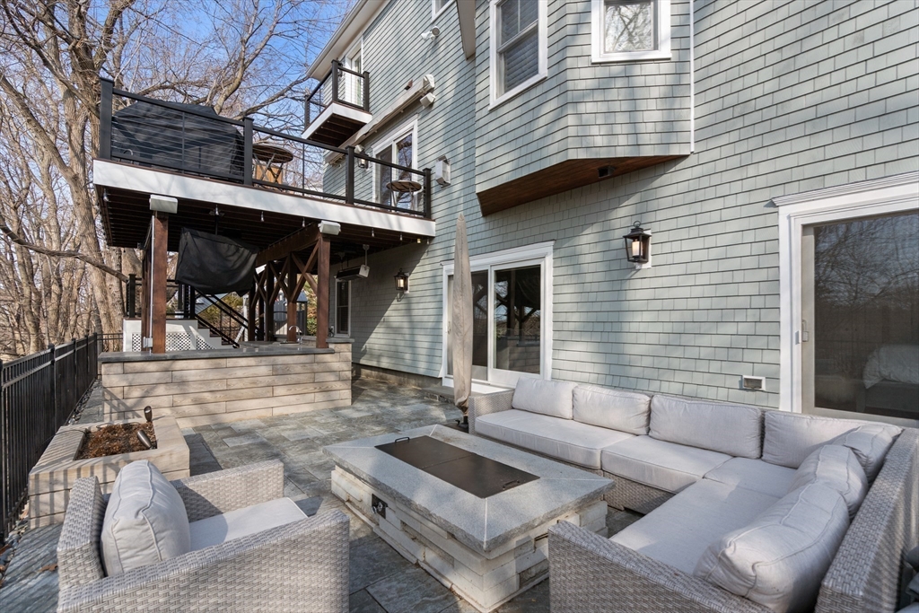96 Oldham Road Newton, MA 02465 - Photo 33 of 40 a view of a patio with couches and a dining table and chairs with wooden floor