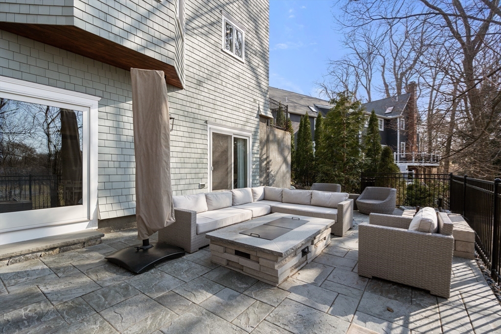 96 Oldham Road Newton, MA 02465 - Photo 34 of 40 a view of a patio with couches and a fire pit next to a road