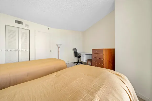 a bedroom with a bed and cabinet
