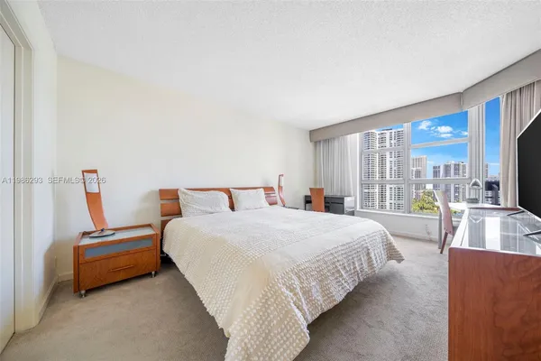 a bedroom with bed and large windows