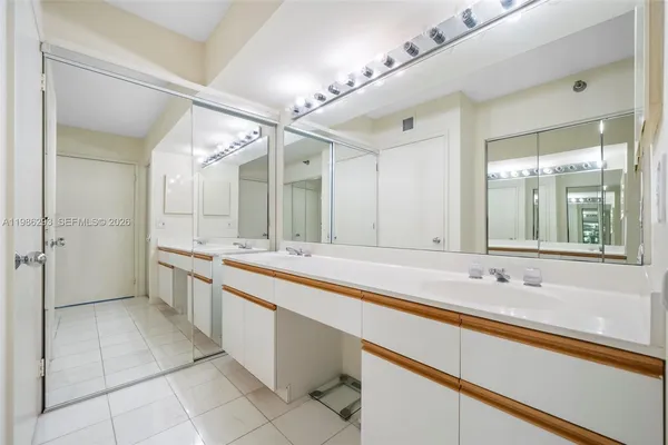 a large bathroom with a double vanity sink a large mirror and a bathtub