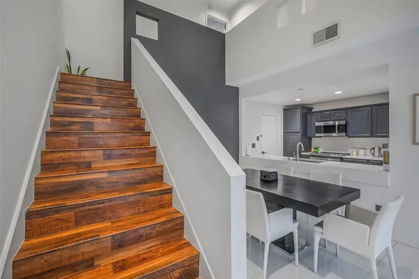 a dinning room with wooden floor and white cabinets