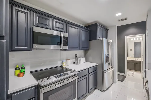 a kitchen with stainless steel appliances a refrigerator a stove top oven a sink and dishwasher