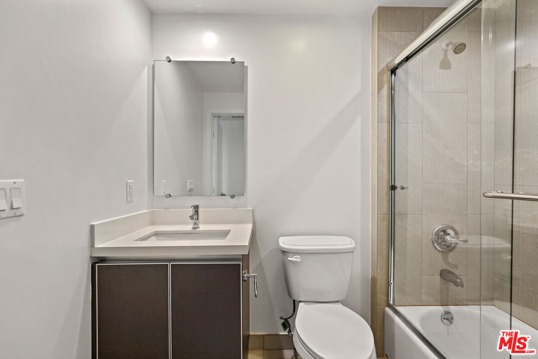 3618 Dunn Drive, Unit 304 Los Angeles, CA 90034 - Photo 12 of 13 a bathroom with a sink toilet and shower