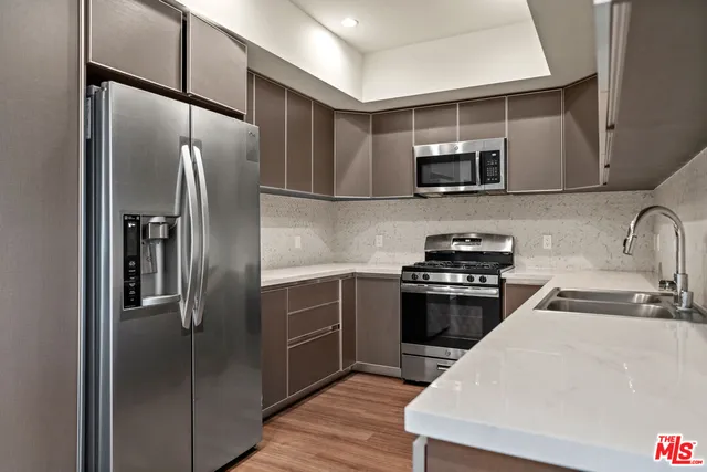 a kitchen with stainless steel appliances kitchen island a refrigerator sink and microwave
