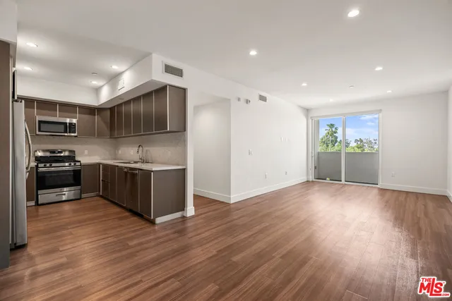 a kitchen with stainless steel appliances kitchen island granite countertop a stove a sink and a refrigerator