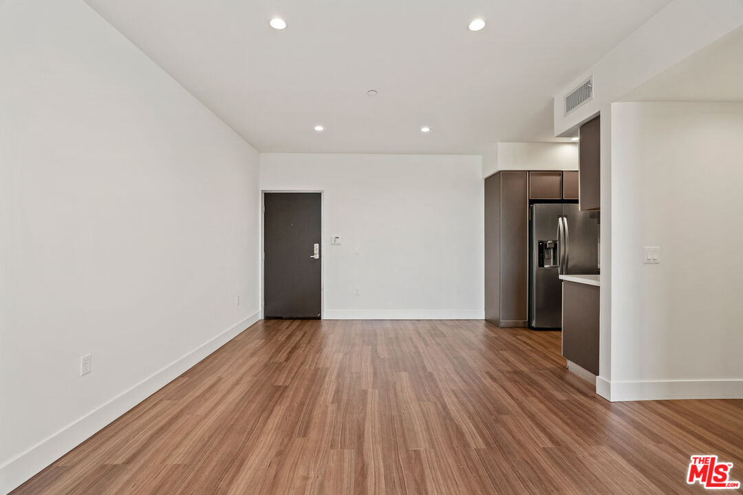 3618 Dunn Drive, Unit 304 Los Angeles, CA 90034 - Photo 5 of 13 a view of a wooden floor and a refrigerator in a room