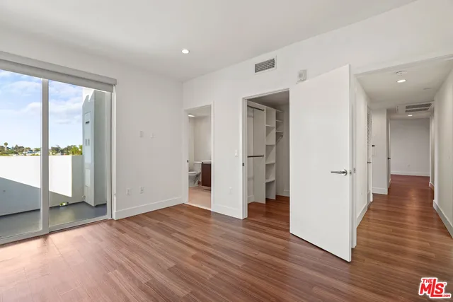 a view of a big room with wooden floor and windows