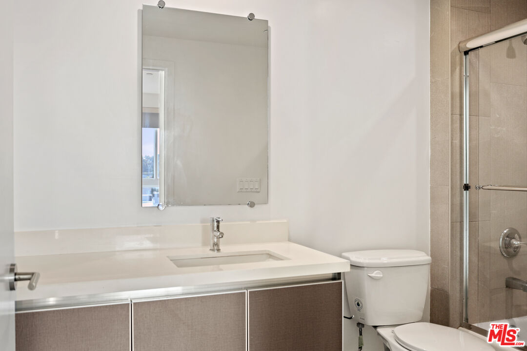 3618 Dunn Drive, Unit 304 Los Angeles, CA 90034 - Photo 10 of 13 a bathroom with a sink toilet and a mirror