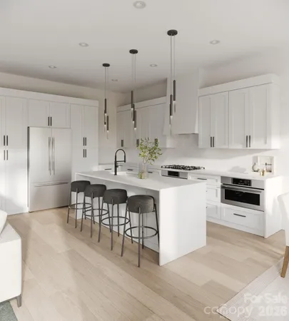 a kitchen with stainless steel appliances kitchen island granite countertop a stove a sink a refrigerator and white cabinets