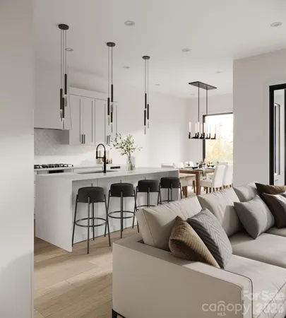 a living room with furniture a chandelier and kitchen view