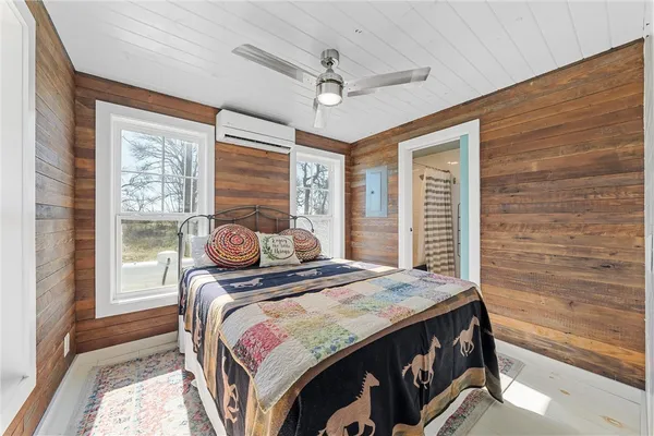 a bedroom with a bed and a large window with the outer view