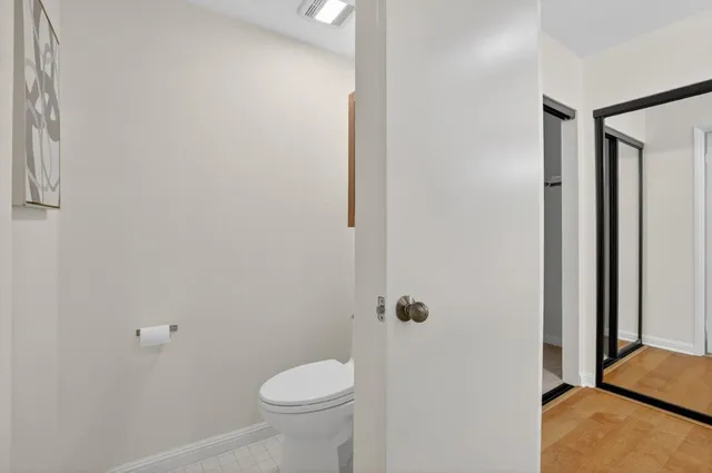 a bedroom with a bed and a lamp on dresser