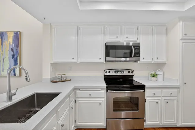 a kitchen with cabinets stainless steel appliances and a sink