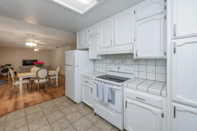 a kitchen with white cabinets and white appliances