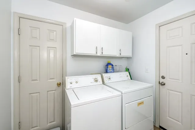 a view of washer and dryer with white cabinets