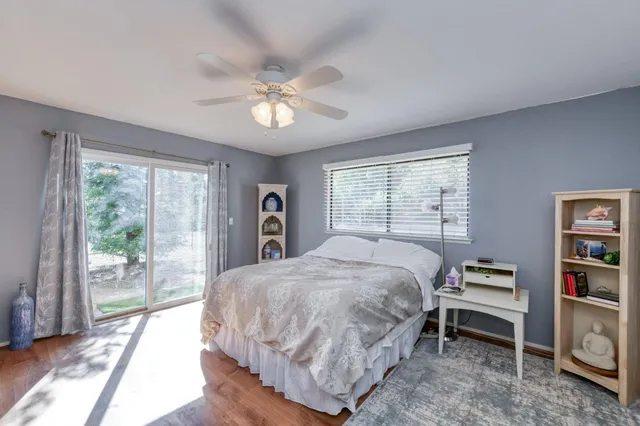 a bedroom with a bed and a large window with the outer view