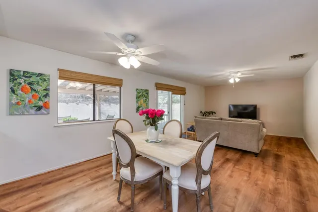 a view of a dining room with furniture a chandelier and wooden floor