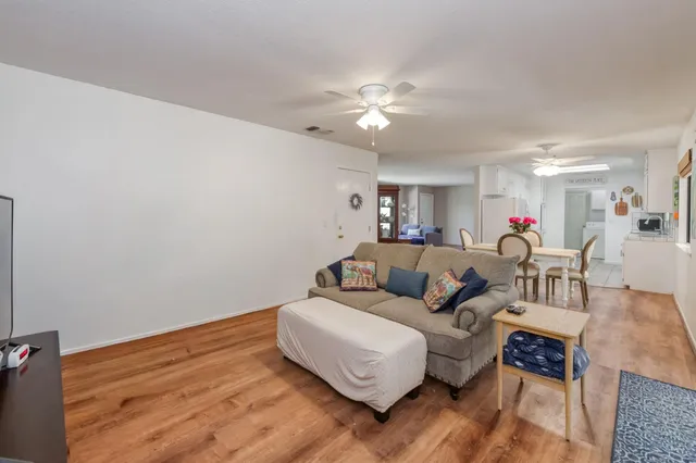 a living room with furniture and a wooden floor
