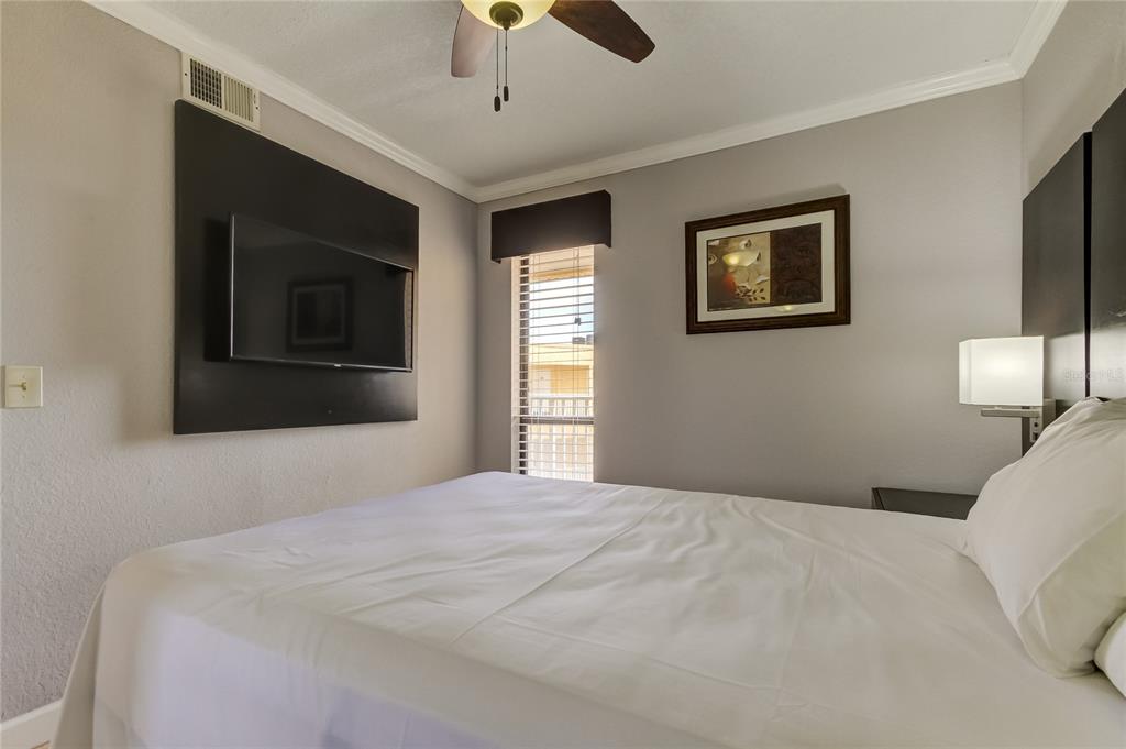 2506 North Rocky Point Drive, Unit 457 Tampa, FL 33607 - Photo 9 of 24 a bedroom with a large bed and a tv