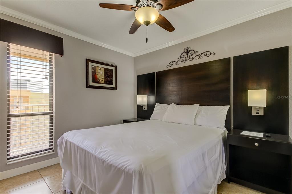 2506 North Rocky Point Drive, Unit 457 Tampa, FL 33607 - Photo 10 of 24 a bedroom with a large bed and a chandelier