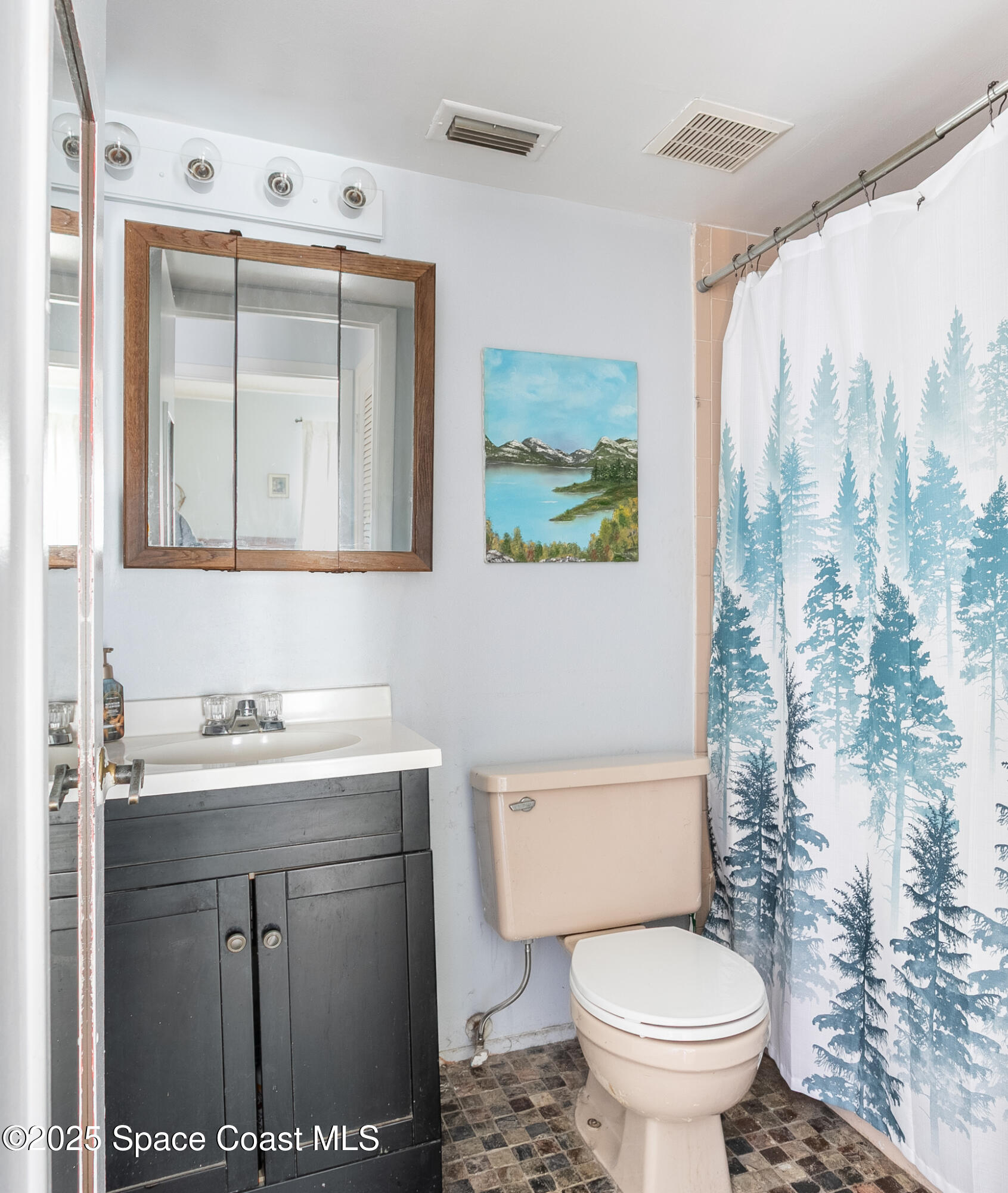 1225 North Wickham Road, Unit 712 Melbourne, FL 32935 - Photo 12 of 24 a bathroom with a toilet sink and mirror