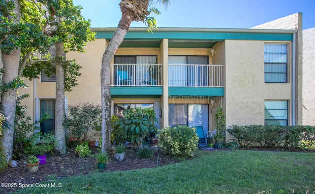a view of a brick house with a yard and plants