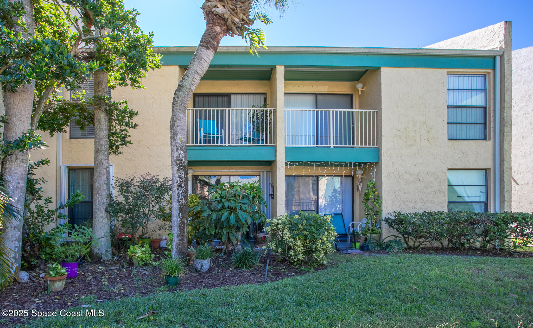 1225 North Wickham Road, Unit 712 Melbourne, FL 32935 - Photo 14 of 24 a view of a brick house with a yard and plants