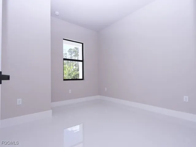 a large white kitchen with kitchen island a sink a stove a refrigerator and white cabinets