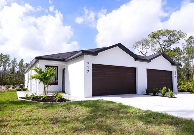 a front view of house with yard and garage