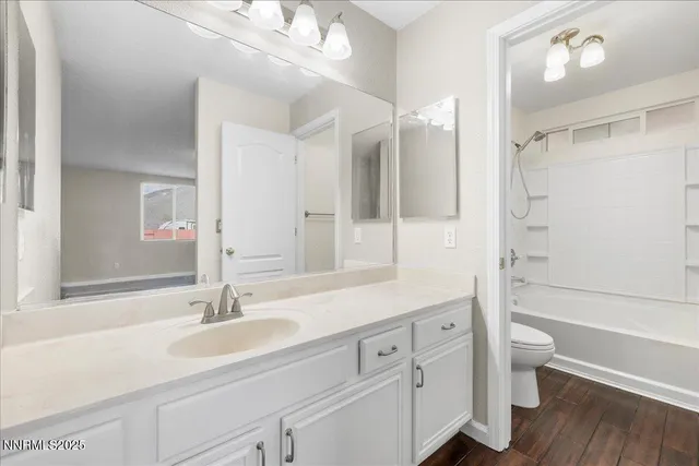 a bathroom with a sink a toilet and a large mirror