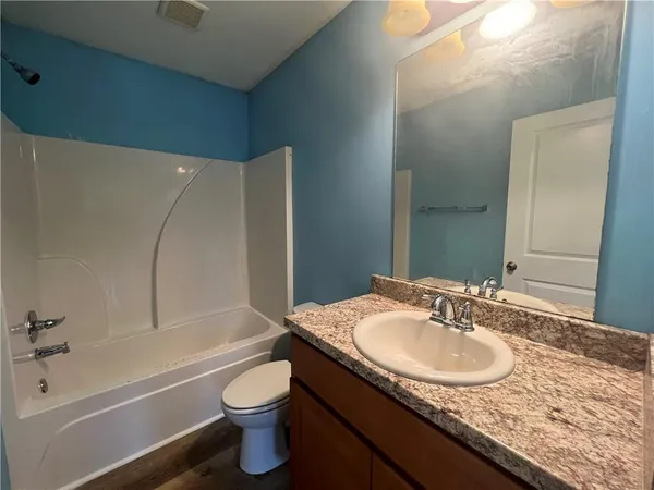 a bathroom with a granite countertop sink toilet and shower