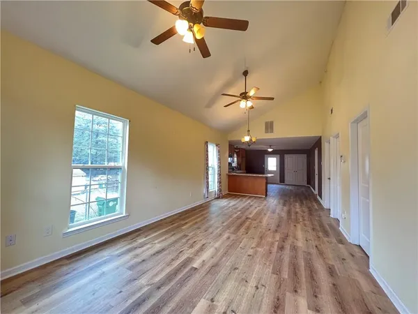 a view of a livingroom with a chandelier fan and a window