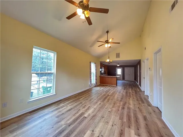 a view of a livingroom with a chandelier fan and a window