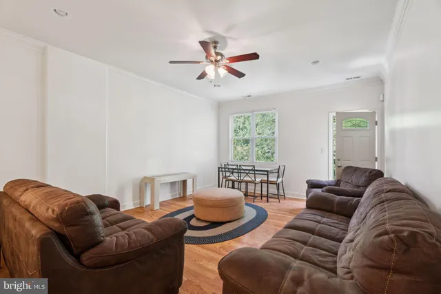 a living room with furniture a ceiling fan and a window