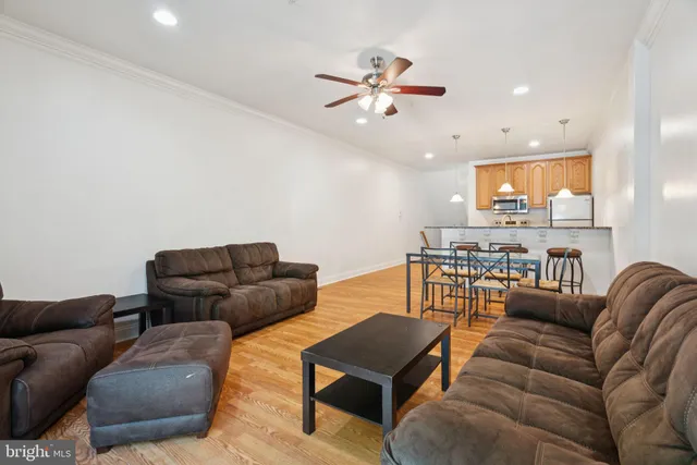 a living room with furniture and a ceiling fan