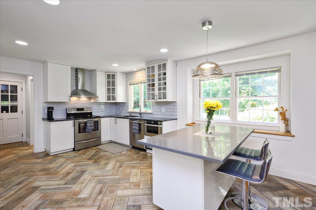 8824 Oneal Road Raleigh, NC 27613 - Photo 14 of 33 a kitchen with stainless steel appliances granite countertop a stove and a refrigerator