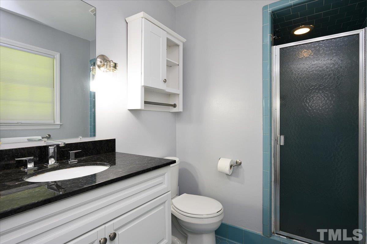 8824 Oneal Road Raleigh, NC 27613 - Photo 31 of 33 a bathroom with a granite countertop sink toilet and mirror