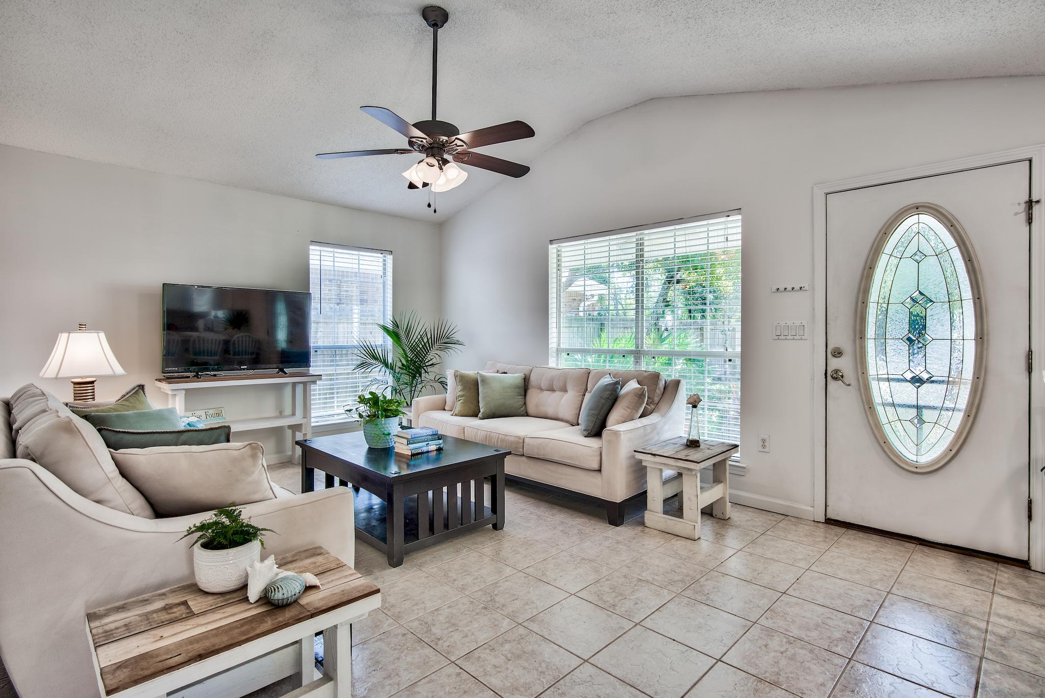 105 Ash Street Santa Rosa Beach, FL 32459 - Photo 5 of 43 a living room with furniture a chandelier and a flat screen tv