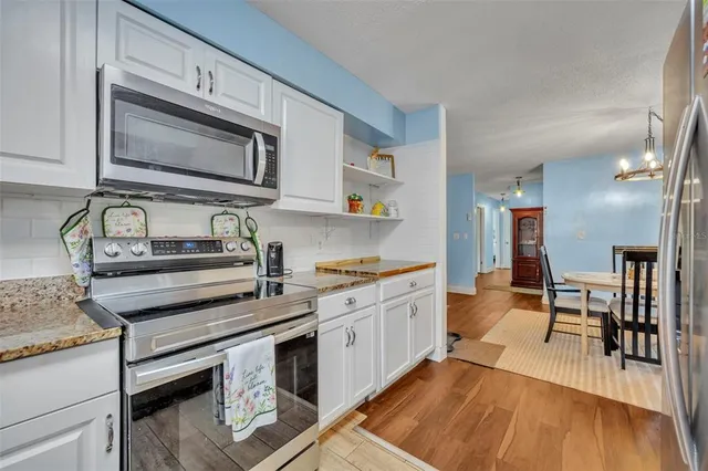 a kitchen with granite countertop a stove and a wooden cabinets