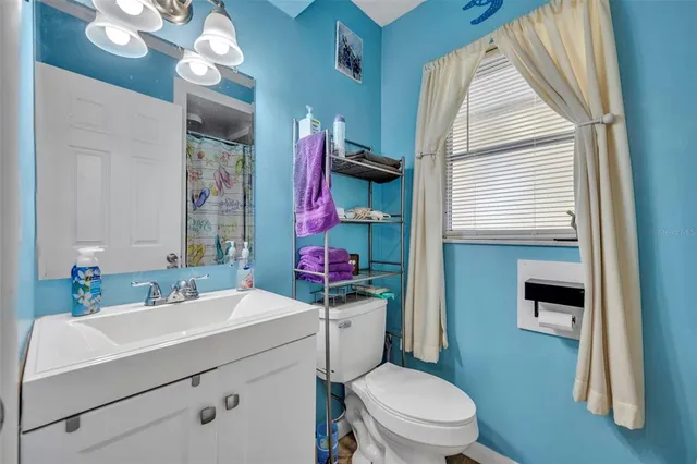 a bathroom with a sink a toilet a mirror and shower